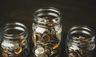 Money jars filled with American currency. Savings and donations concept.