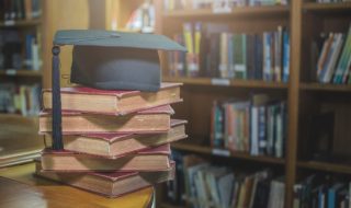 graduation cap on Books step in Library room