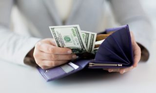 close up of woman hands with wallet and money
