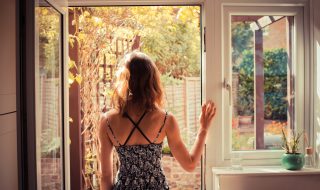 Woman standing in doorway at sunrise