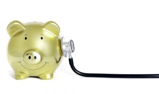 Yellow piggy bank with stethoscope on his side