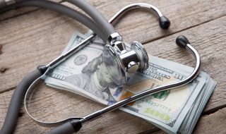 health insurance concept - stethoscope over the money
